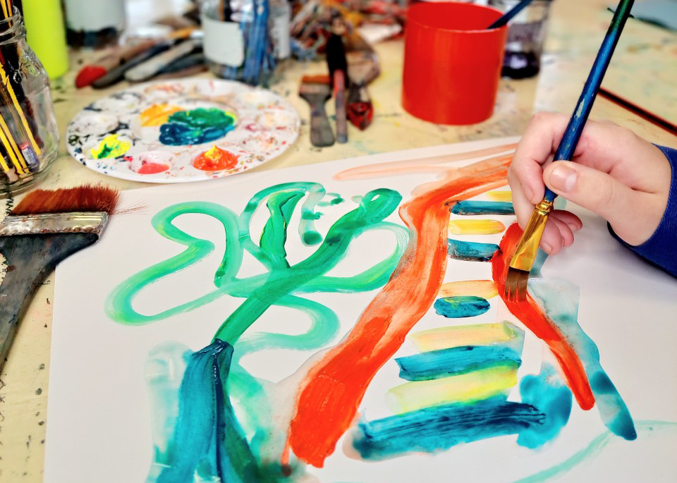 cropped image of someone's hand painting a colourful abstract painting