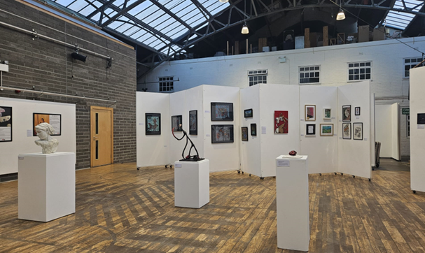 View of the whole exhibition in Edinburgh, a large hall with artworks on boards and plinths