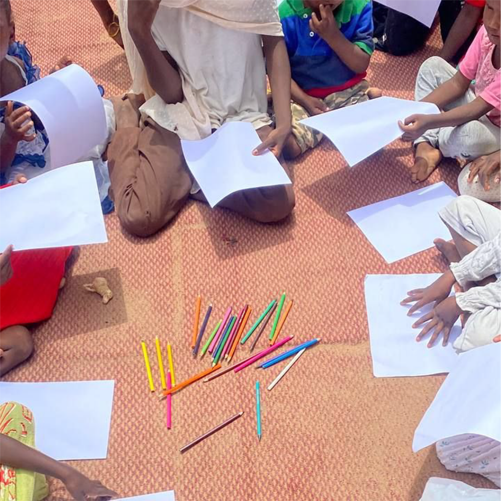 a group of children with drawing paper and pencils