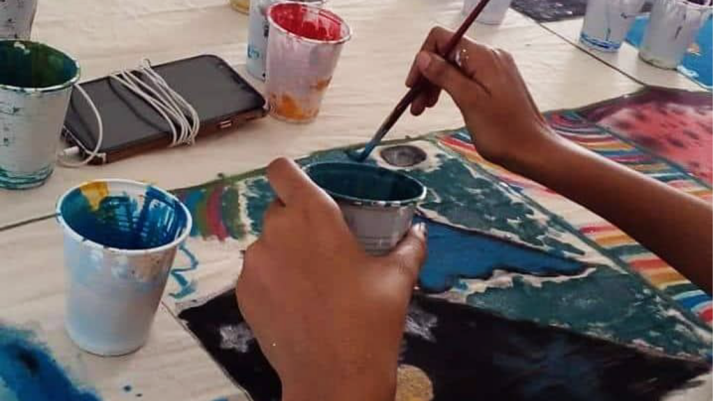 the view of a pair of hands painting a picture